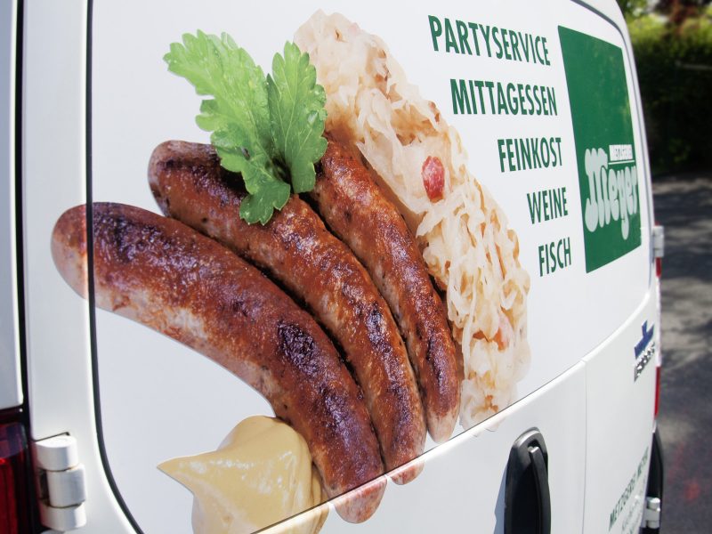 Detailaufnahme der Folierung des Lieferwagens der Metzgerei Meyer mit ansprechenden Food-Aufnahmen und großem Logo