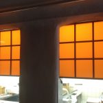 Plexiglasschilder mit orangfarbener Folie über einer Durchreiche