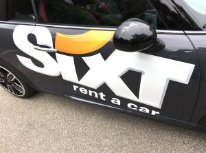 Großflächige Beklebung des Sixt Logos auf schwarzem Fahrzeug