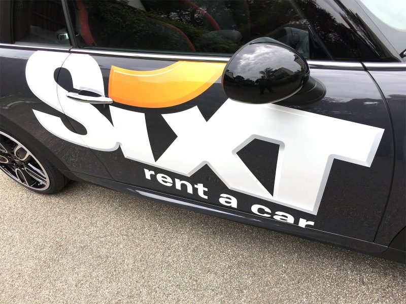 Großflächige Beklebung des Sixt Logos auf schwarzem Fahrzeug