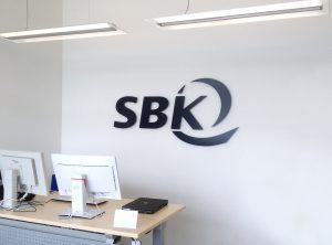 3D Logo der Firma SBK an weißer Wand