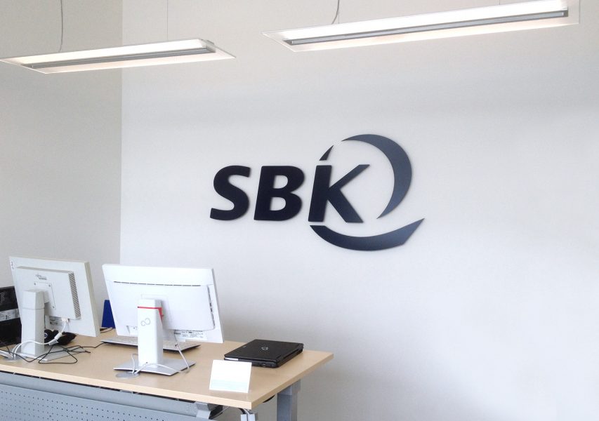 3D Logo der Firma SBK an weißer Wand
