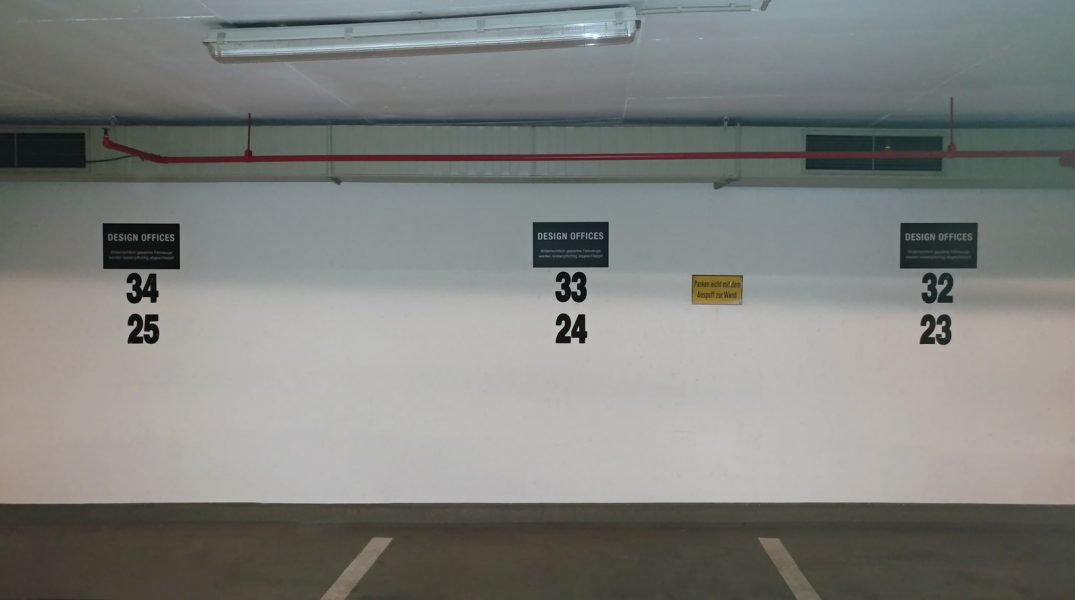 Montage von Schildern zur Parkplatzkennzeichnung in einem Parkhaus