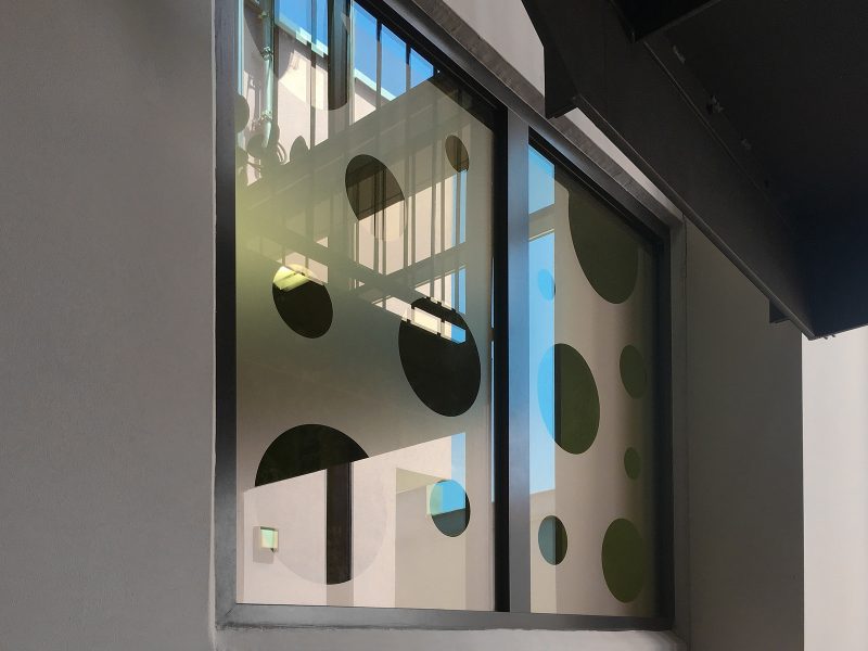 Sichtschutzbeklebung aus Glasdekor mit schwarzen Kreisen in unterschiedlichen Größen aufgelockert