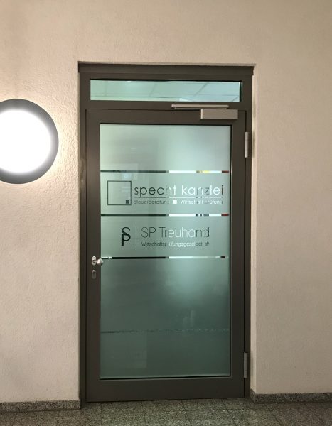 Folierung einer Eingangstüre mit Glasdekor und negativ herausgeschnittenen Streifen und Logos