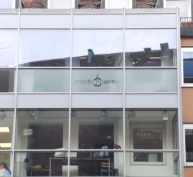 Folierung einer Fensterreihe mit Glasdekorflächen und Flächen mit negativ herausgeschnittenem Logo