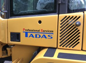 Beklebungsarbeiten - Baggerbeklebung für die Firma Tadas mit Logo