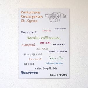 Schilder - Schild auf weißer Hausfassade für den Katholischen Kindergarten St. Xystus
