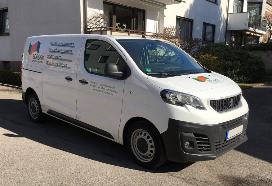 Fahrzeugbeklebung - Schrägansicht eines weißen Peugeot mit neuer Fahrzeugbeschriftung für Schenk Equisit Wohnen