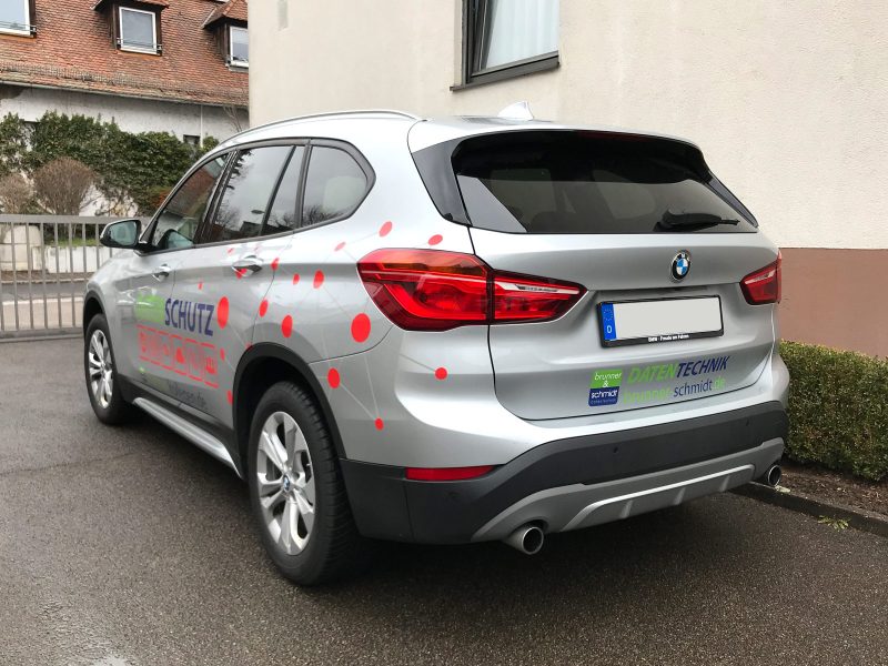 Fahrzeugbeschriftung - Schrägansicht eines silbernen BMW X1 mit neuer Fahrzeugfolierung für Brunner und Schmidt