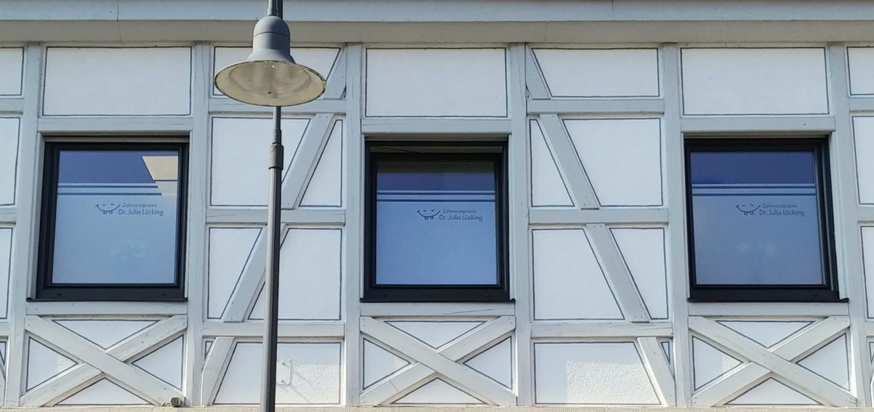 Sichtschutzfolierung - von innen angebracht an einem Fenster der Zahnarztpraxis und von außen fotografiert.