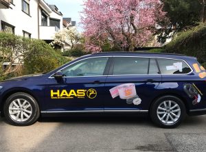 Fahrzeugbeklebung - Seitenansicht eines dunkelblauen Passats mit neuer Fahrzeugbeschriftung für die Firma Haas