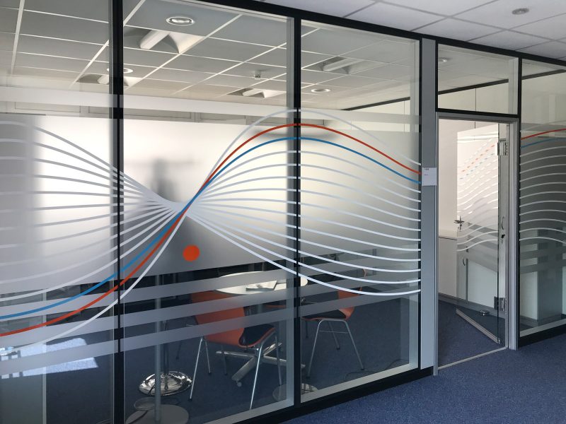 Sichtschutzfolierung aus Milchglasfolie mit darauf geklebten farbigem Muster auf einer Glasfront in Büroräumlichkeiten der Firma isyst