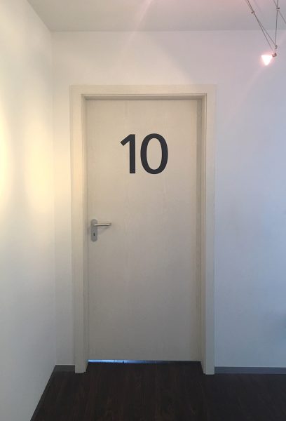 Alphablaue Türnummer "10" für einen Behandlungsraum in der Praxis von Zahnarzt Ludwig in Fürth