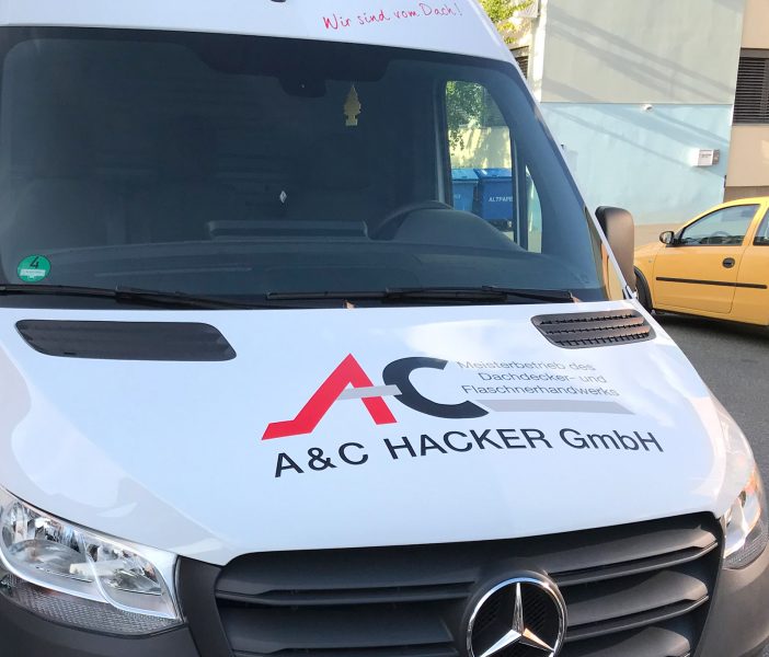 Fahrzeugbeklebung - Deteilansicht der Front eines weißen Lieferwagens mit neuer Folienbeschriftung für A und C Hacker