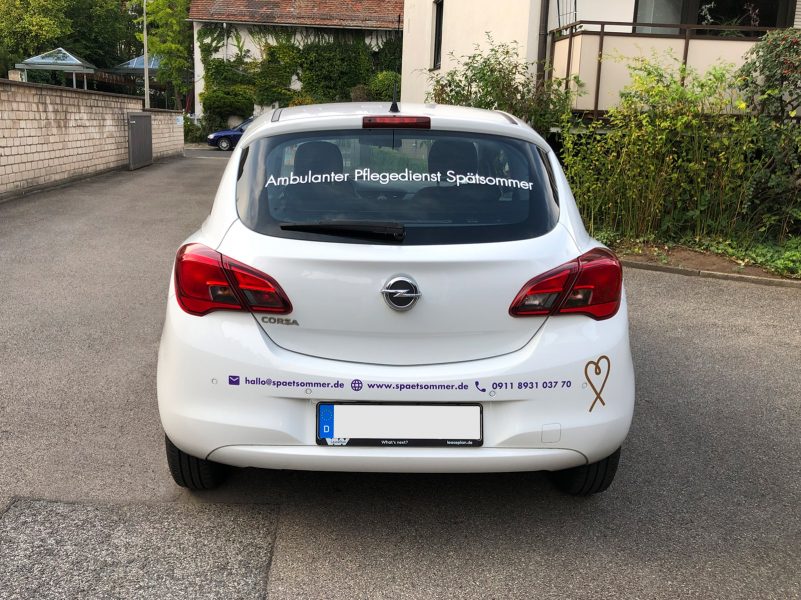 Fahrzeugfolierung - Heckansicht eines weißen Opel mit Beklebung für Spätsommer Pflegedienst