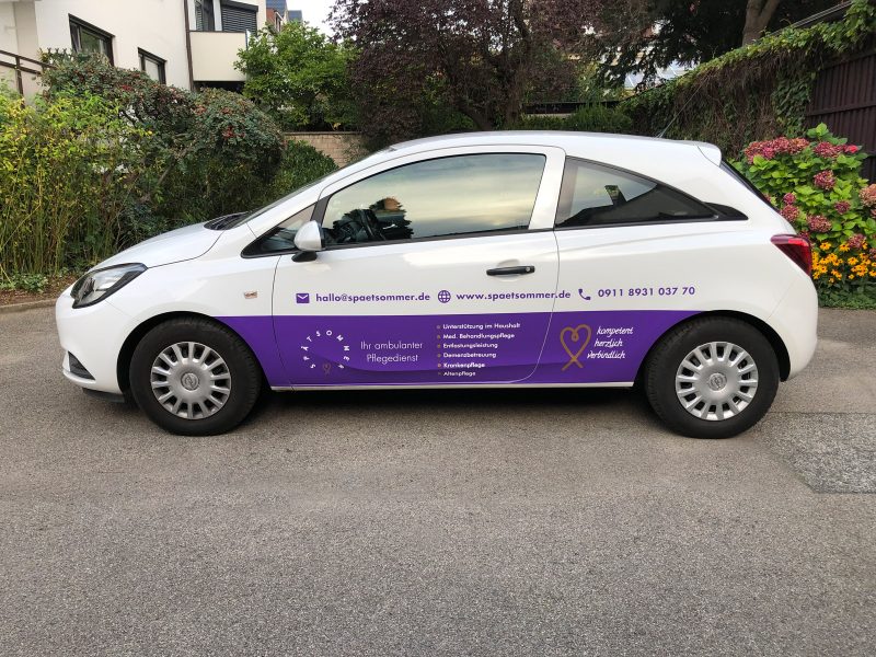 Fahrzeugfolierung - Seitenansicht eines weißen Opel mit Beklebung für Spätsommer Pflegedienst