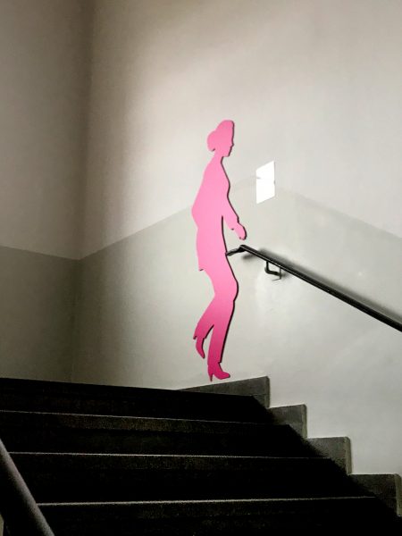Pinke weibliche Schattenfigur in einem Treppenhaus an der Wand
