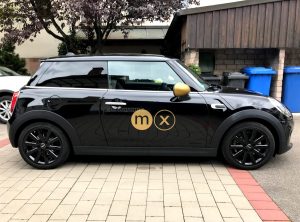 Fahrzeugfolierung - Seitenaufnahme von schwarzem Mini mit Logo in Goldfolie von moox