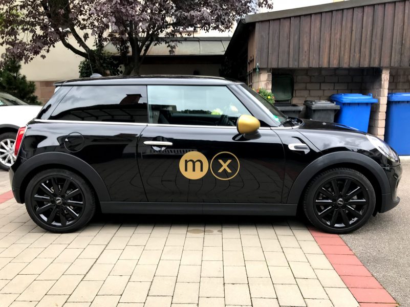 Fahrzeugfolierung - Seitenaufnahme von schwarzem Mini mit Logo in Goldfolie von moox