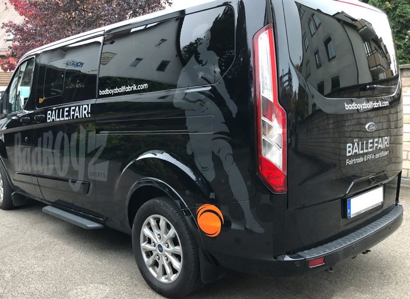 KFZ-Beklebung - Seiten- und Heckansicht eines schwarzen Transporters mit einer neuen großflächigen Fahrzeugbeklebung von Badboyz Ballfabrik