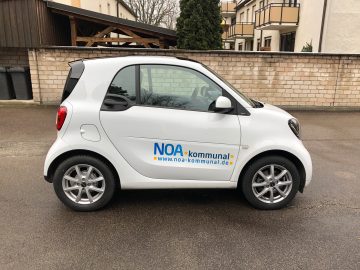 Fahrzeugbeklebung - Weißer Smart mit einem NOA kommunal Logo an der Seite