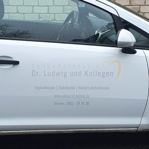 KFZ-Beklebung - Weiße Opel Corsa Türe mit dezenter Folienbeschriftung von Zahnarzt Ludwig