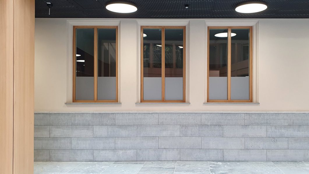 Sichtschutzbeklebung - Hohe Fenster mit Holzrahmen, die etwa ein drittel mit Glasdekorfolie abgedeckt sind