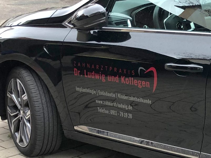 Fahrzeugbeschriftung - Türe eines schwarzen Clios mit Beklebung für Dr Ludwig und Kollegen