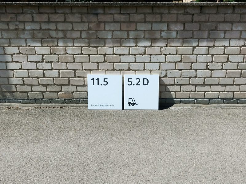 Frontaufnahme: 2 Schilder mit neuer Folienbeschriftung an eine Mauer gelehnt für Siemens Technopark Nürnberg