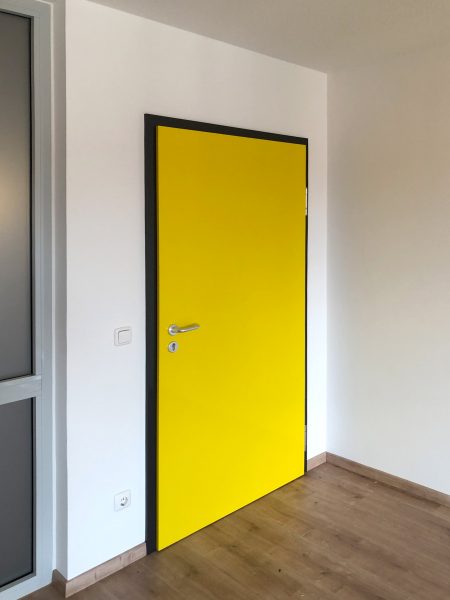 Tür-Vollfolierung - Schwarzer Türrahmen und gelbes Türblatt im Auftrag der Diakonie