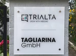 Acrylglas-Schild an einem Gartenzaunpfosten für Trialta