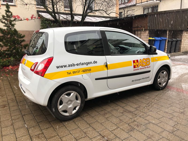 Fahrzeugbeklebung - Schräge Seitenansicht eines frisch folierten weißen Twingo für ASB Erlangen-Höchstadt