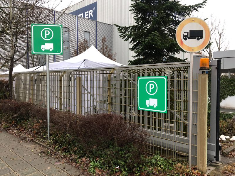 Schilder - LKW Parkplatzschild an einem Zaun und einer Stange bei Staedtler