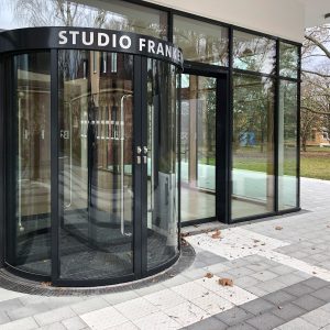 Folierung und Beschilderung - Eingangstüre und Eingangsfront mit Durchlaufschutz und Firmenbeschilderung von außen fotografiert
