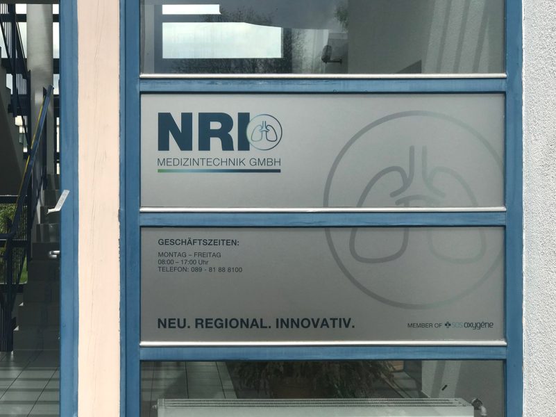 Firmenbeschilderung - Sichtschutzfolierung mit Logos an Eingang für das NRI