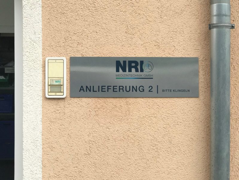 Firmenbeschilderung - Edelstahl gebürstetes NRI Schild an Fassade