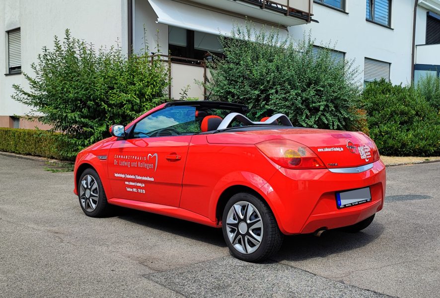 Flottenbeschriftung - Schräge Heckansicht eines roten frisch folierten Opel Tigra für Zahnarzt Ludwig