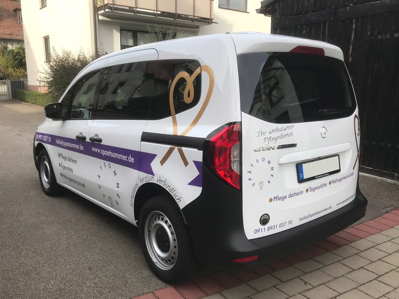 Fahrzeugfolierung - Schräge Heckansicht eines Mercedes Citan mit neuer Fahrzeugbgeklebung für den Spätsommer Pflegedienst