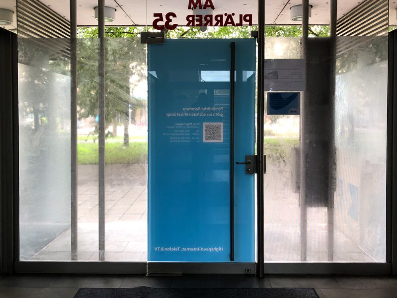Sichtschutz mit Lochfolie an der Eingangstüre von M-net in Nürnberg von innen