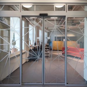 Indoor-Beklebung - Gitterdesign Folierung von Glaswand mit Türelement