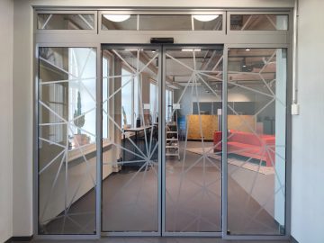 Indoor-Beklebung - Gitterdesign Folierung von Glaswand mit Türelement