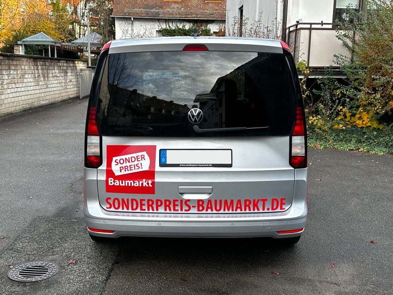 Reparaturfolierung - Heckansicht eines silbernen VW Caddy mit neuer Folienbeschriftung für Sonderpreis Baumarkt
