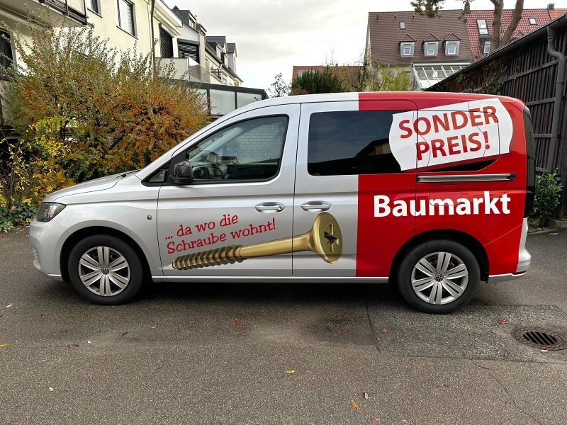 Reparaturfolierung - Fahreransicht eines silbernen VW Caddy mit neuer Folienbeschriftung für Sonderpreis Baumarkt