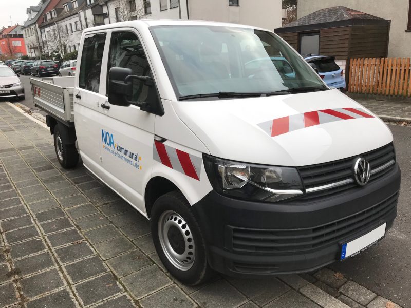 Fahrzeugfolierung - Schräge Seitenansicht eines neu folierten weißen VW T6 für NOA kommunal