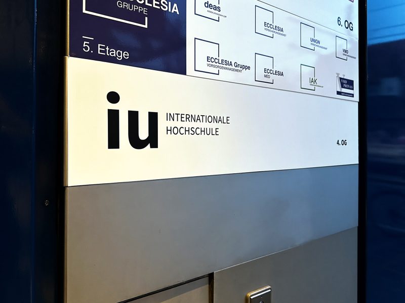 Campusfolierung an der IU in Nürnberg - Schildaufkleber mit IU Logo an Eingang innen