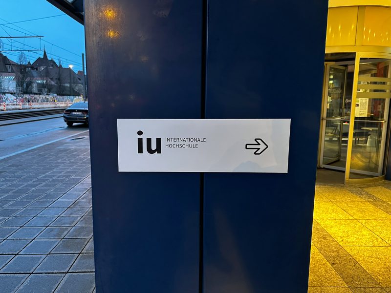 Campusfolierung an der IU in Nürnberg - Außenschild mit IU Logo