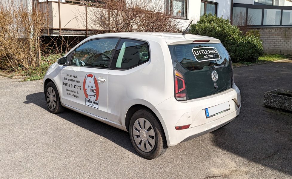 Fahrzeugbeschriftung - Seiten- und Heckansicht eines weißen VW Up mit frischer Folienbeschriftung