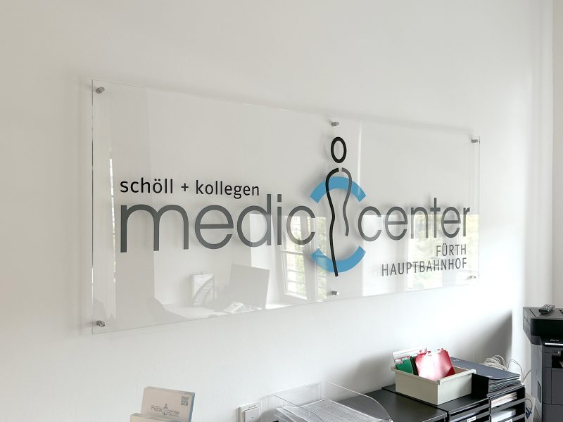 Logo des medic center auf Acrylglas mit Abstandshalter
